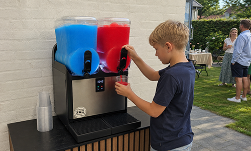 Dreng tapper slush ice fra maskine til havefest